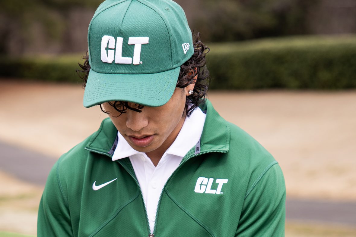 student in athletic gear looking down with hat covering eyes