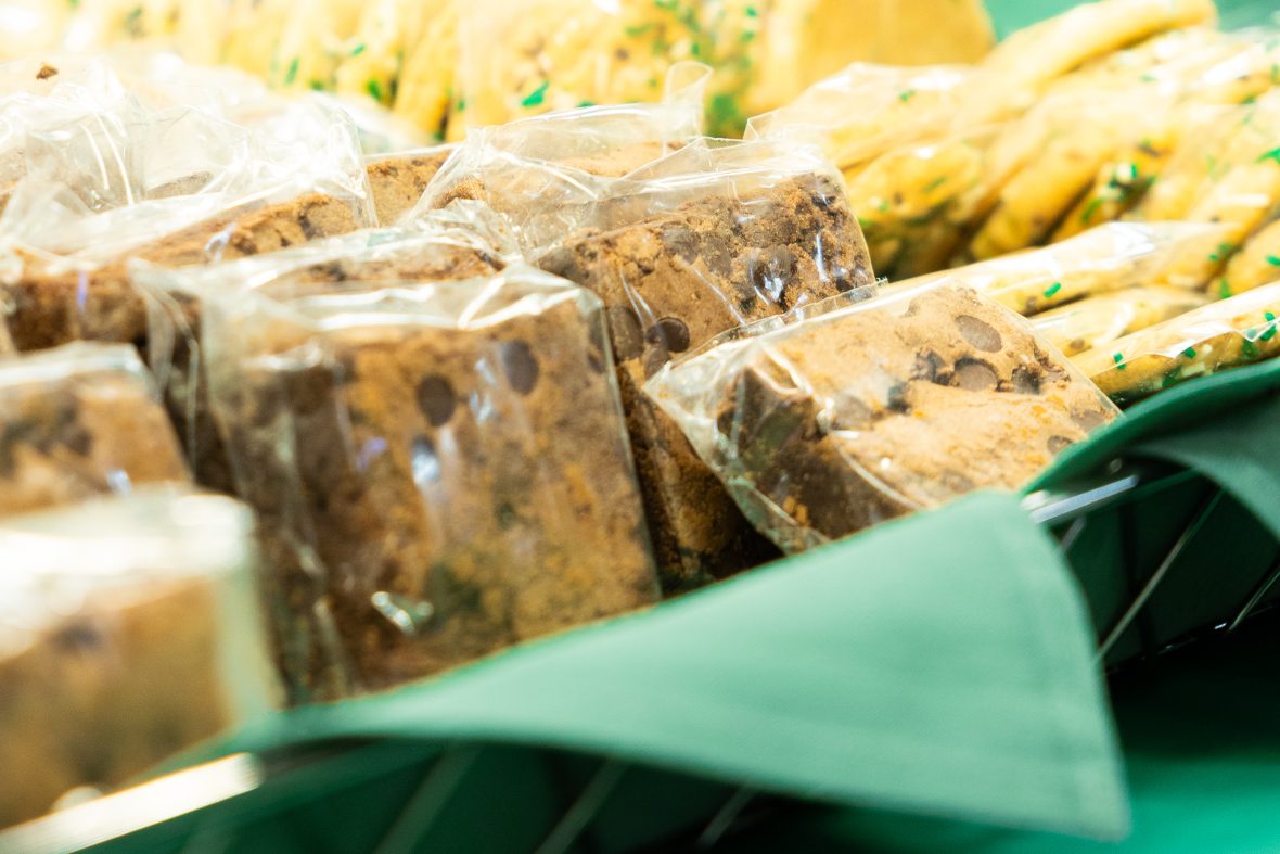 individually-wrapped brownies and cookies in basket with green napkins