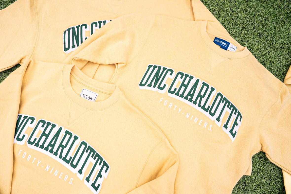 yellow sweatshirts laid in a stack with UNC Charlotte text embroidered on front